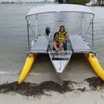 Person on a boat with two-sided outriggers