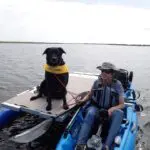 A person and a dog on a boat with a one-side outrigger