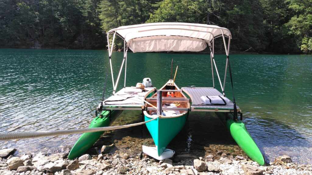 A small boat with a roof with two modular outriggers